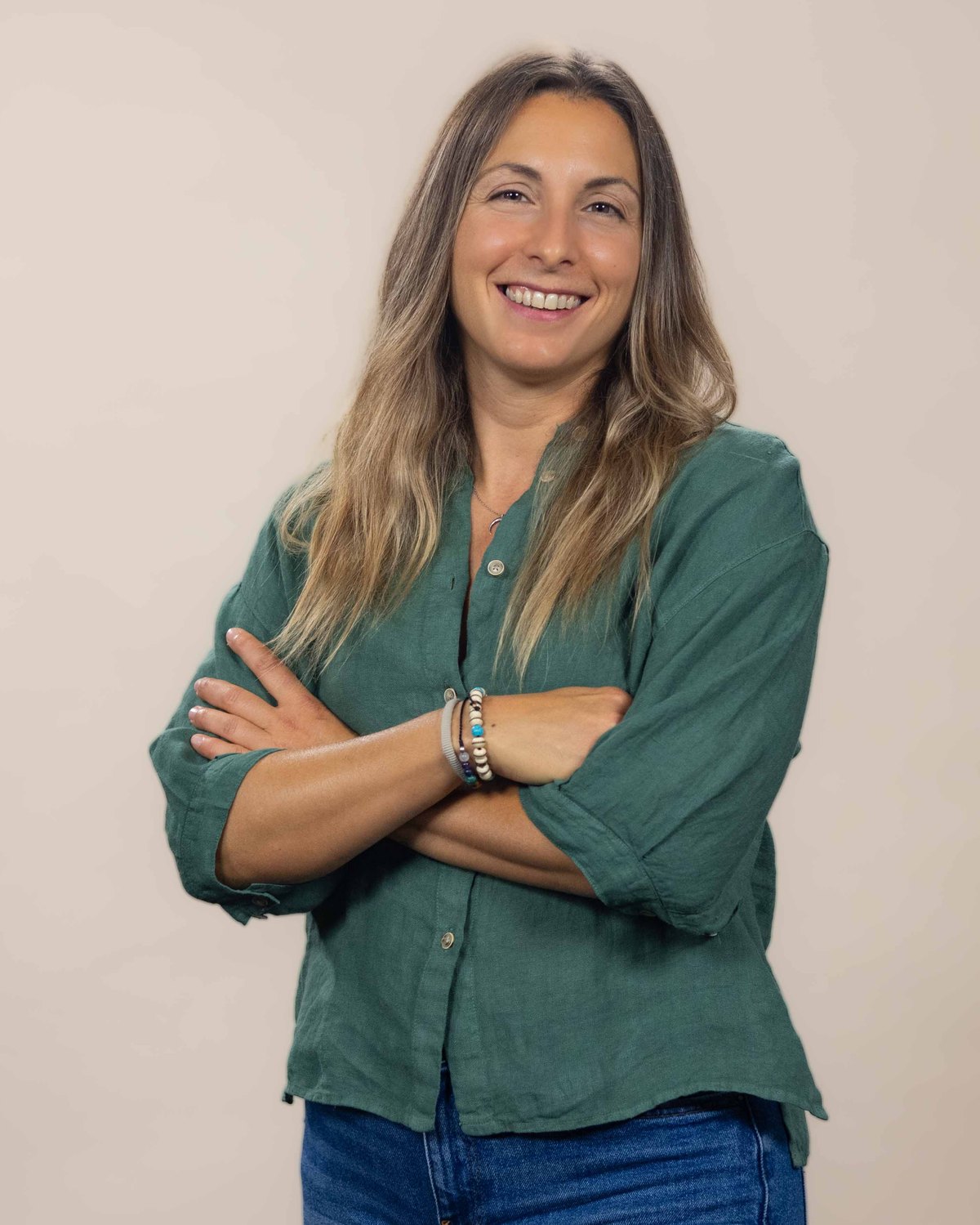 Retrato de la Dra. Irene Escudero Martínez, neuróloga, con los brazos cruzados sobre fondo claro.